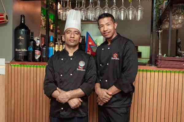 Chefe principal e segundo chefe do restaurante Royal Spice em Lisboa, à frente do balcão do restaurante.